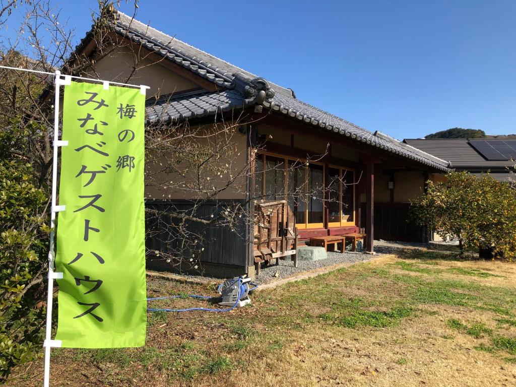 un edificio con una pancarta delante de él en みなべゲストハウス en Minabe