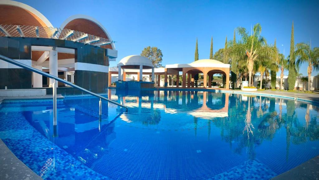 a large swimming pool next to a building at Hotel María Dolores San Luis Potosí in San Luis Potosí