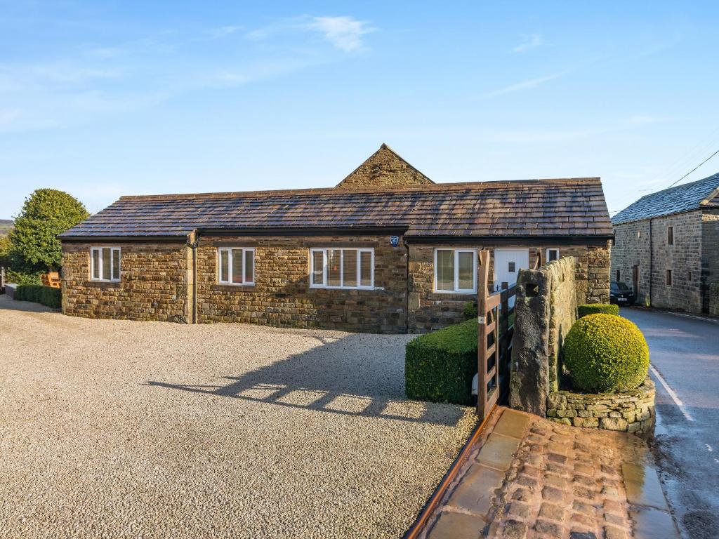 a brick house with a fence in front of it at The Cottage in Langsett