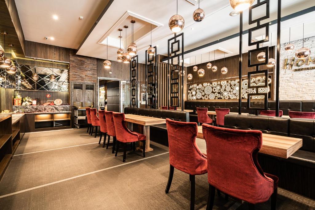 a restaurant with red chairs and tables and a bar at Global Traveler Hotel in Kaohsiung