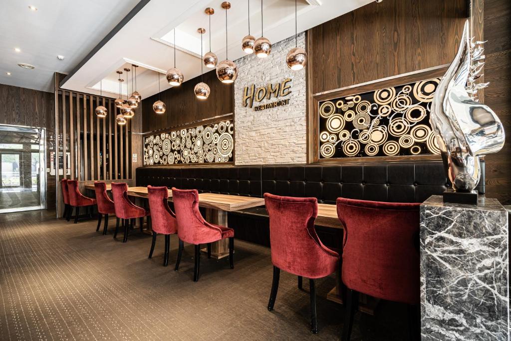 a dining room with red chairs and a bar at Global Traveler Hotel in Kaohsiung