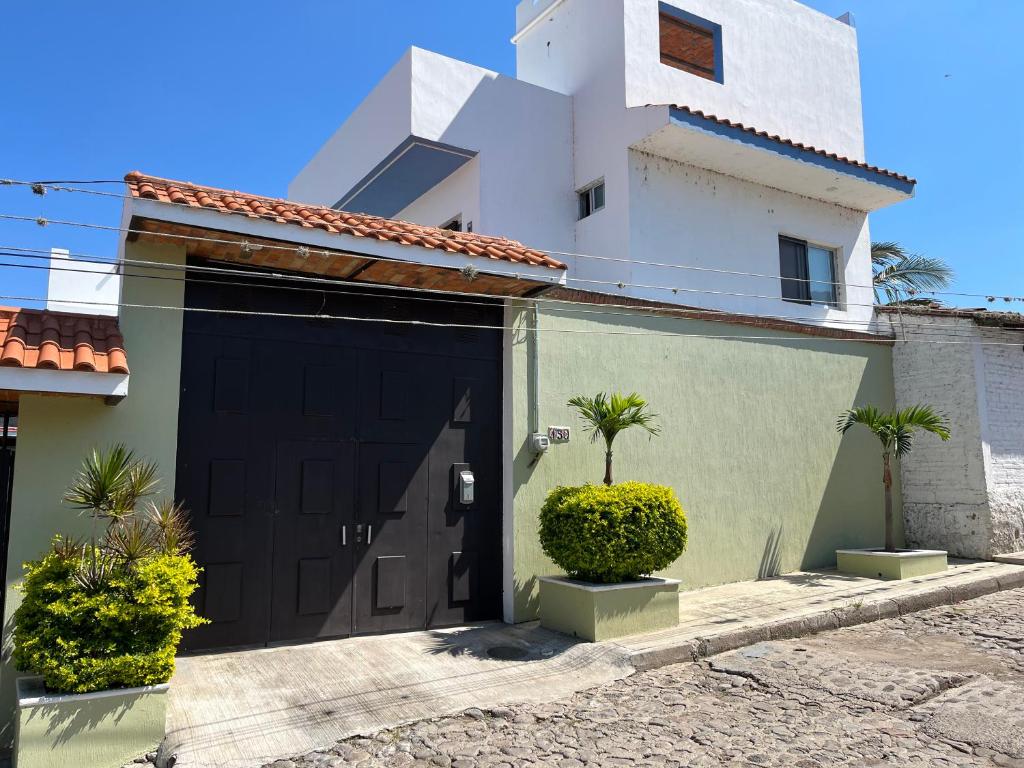 a garage with a black door in front of a house at Departamentos San Pedro in San Pedro Tesistán