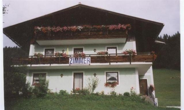 Casa blanca con balcón con flores. en Privatzimmer Anneliese en Gosau