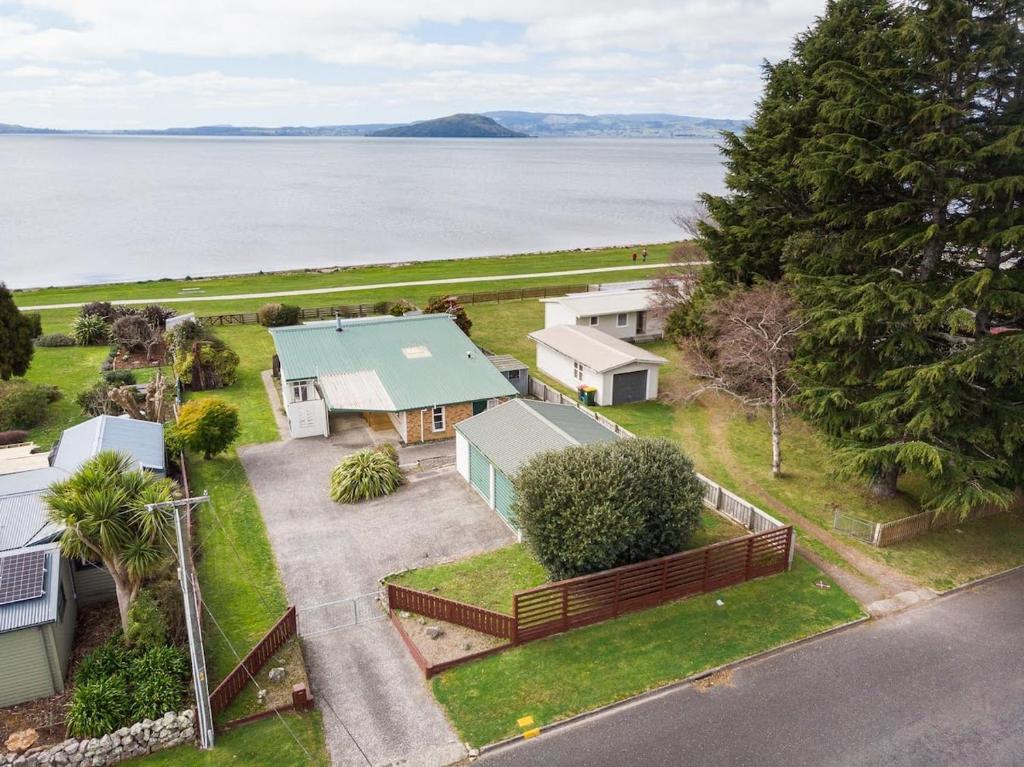 an aerial view of a house next to the water at Daydream house, Sunrise, sunset views across lake in Rotorua