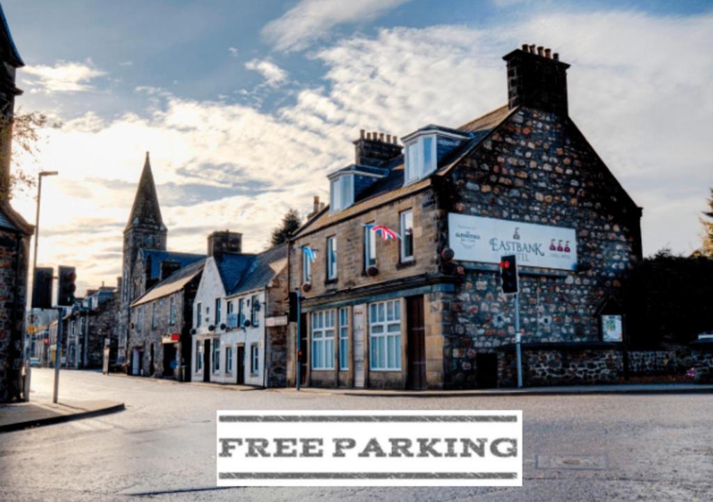 a tree parking sign in front of a building at OYO Eastbank Hotel, Speyside Scotland in Rothes