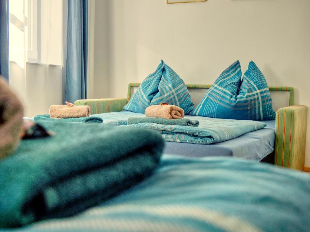 two beds with blue pillows in a room at Gasthof zum Postwirt in Predlitz