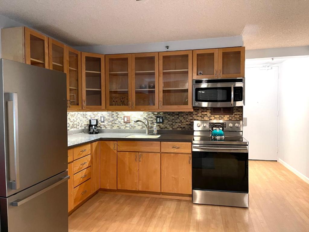 a kitchen with wooden cabinets and a stainless steel appliances at Marine Surf in Honolulu