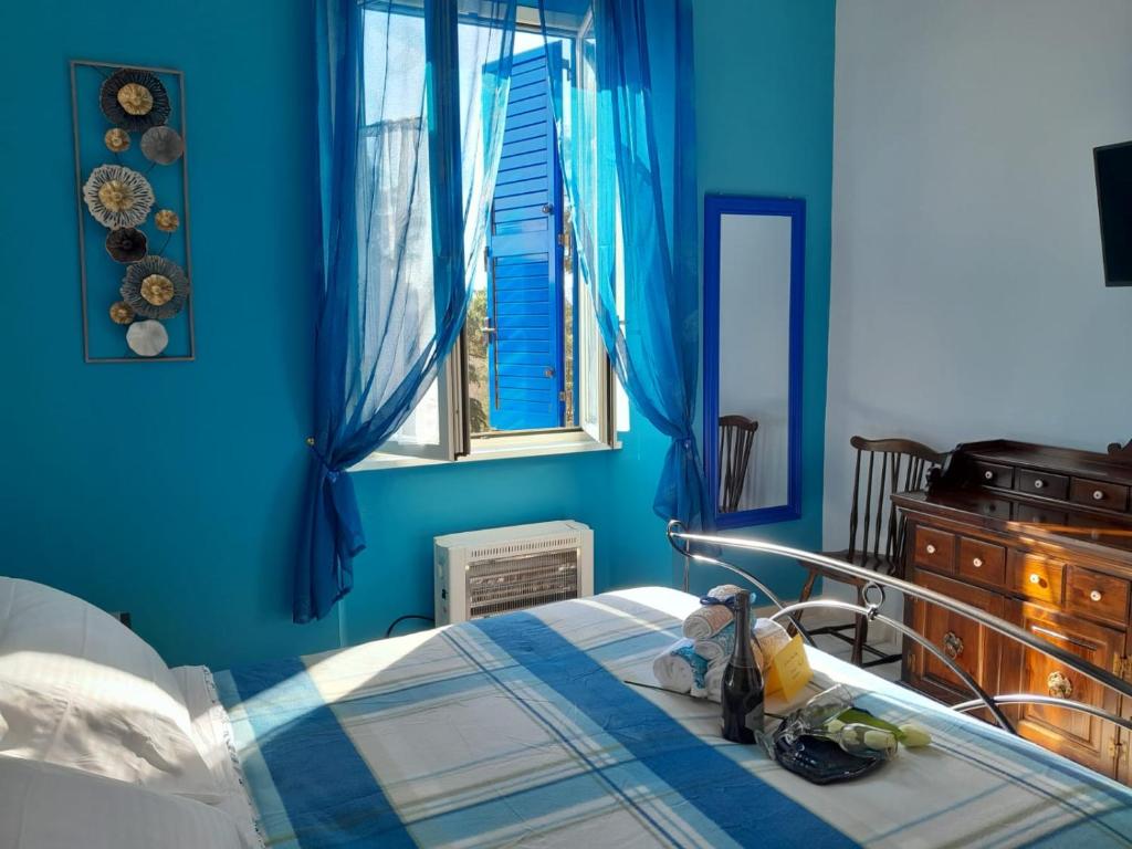 een blauwe slaapkamer met een bed en een raam bij La Casa di Carta FIUGGI in Fiuggi