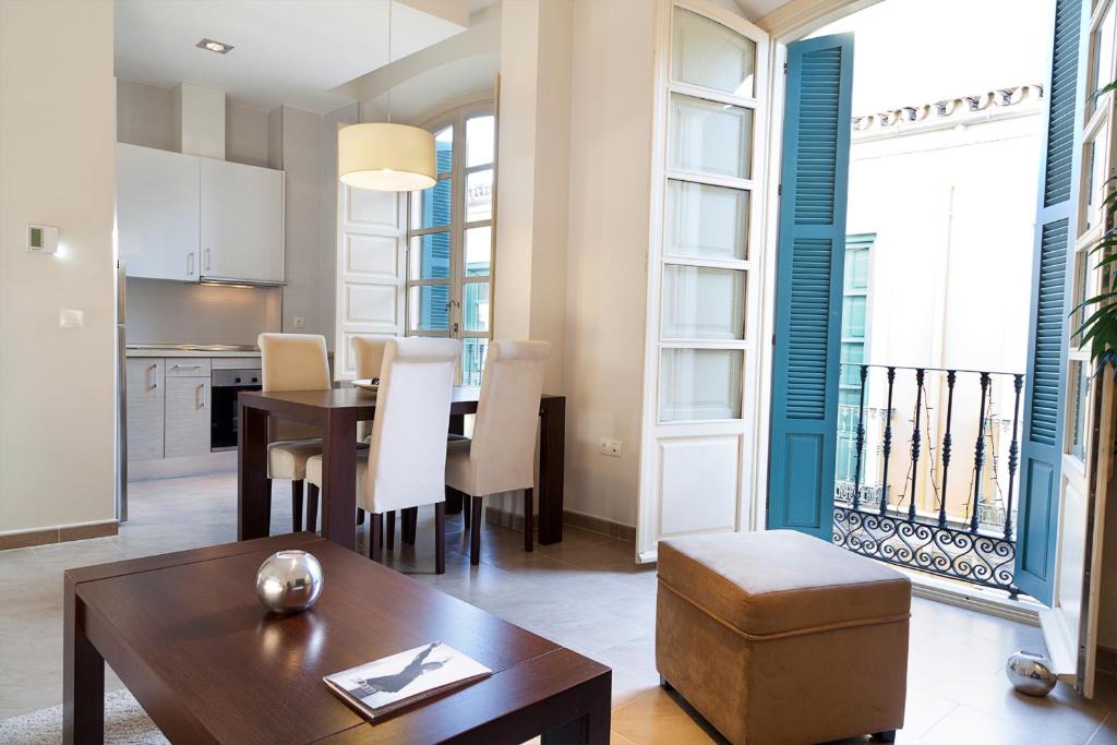 cocina y sala de estar con mesa y sillas en Apartamentos Pinar Malaga Centro, en Málaga
