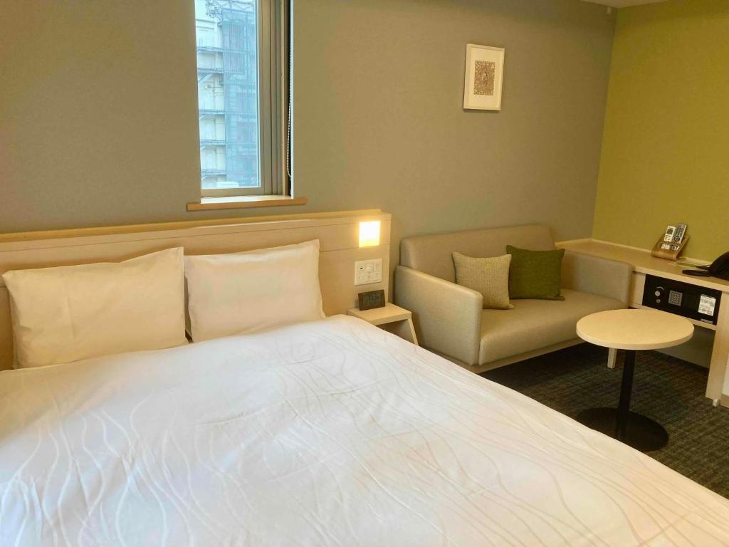 Postel nebo postele na pokoji v ubytování Dormy Inn Premium Ginza