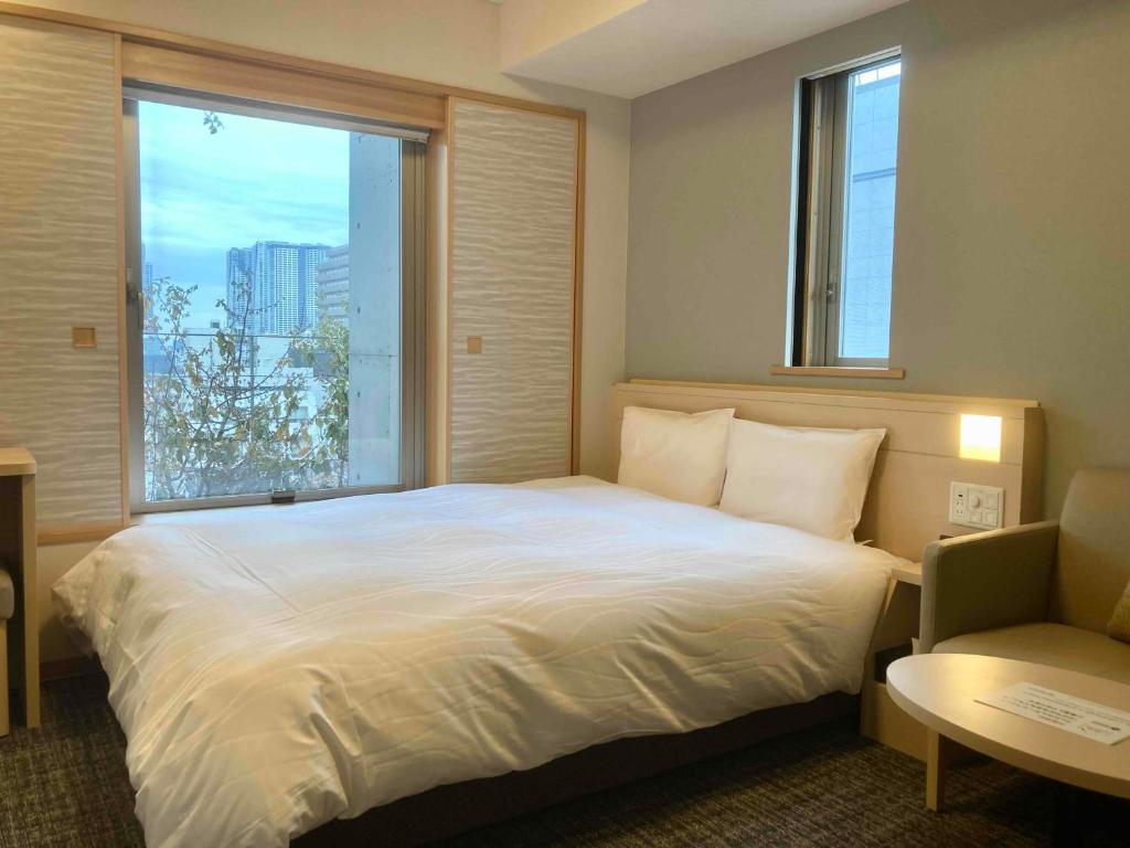 Postel nebo postele na pokoji v ubytování Dormy Inn Premium Ginza
