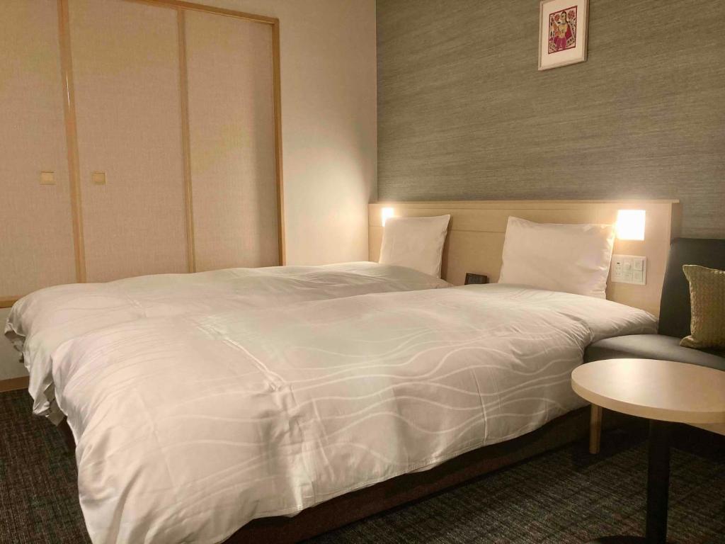 Postel nebo postele na pokoji v ubytování Dormy Inn Premium Ginza