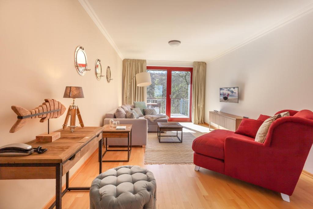 un soggiorno con divano rosso e sedia rossa di HIDDENSEE I mit Ostseeblick Haus Fore a Lohme