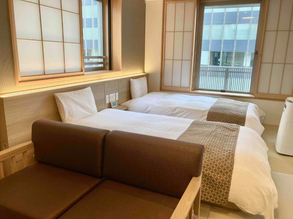 Postel nebo postele na pokoji v ubytování Dormy Inn Premium Ginza