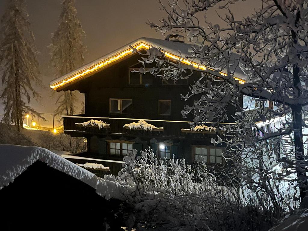 海利根布卢特Bauernhof Stempf的雪覆盖的房屋,晚上有灯