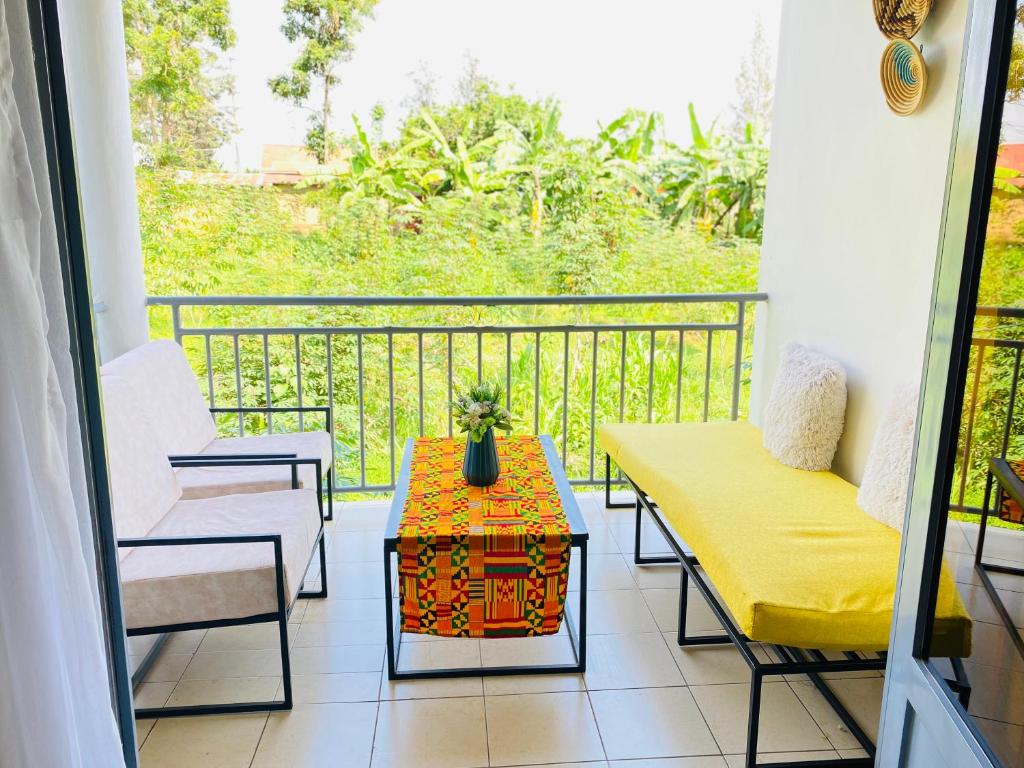 uma varanda com uma mesa e cadeiras. em F&H 2 Bedroom cozy - Kigali apartment unit em Kigali