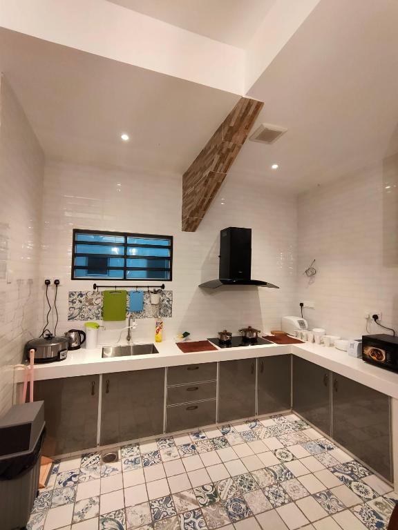 a kitchen with a sink and a counter top at Cameron Lovely Cottage 3 Rooms in Tanah Rata