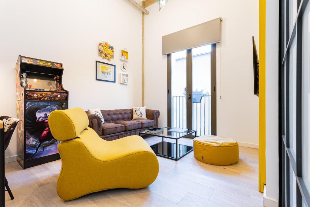 a living room with a yellow chair and a couch at UrBaN ArT Historic Center @Mellow in Málaga