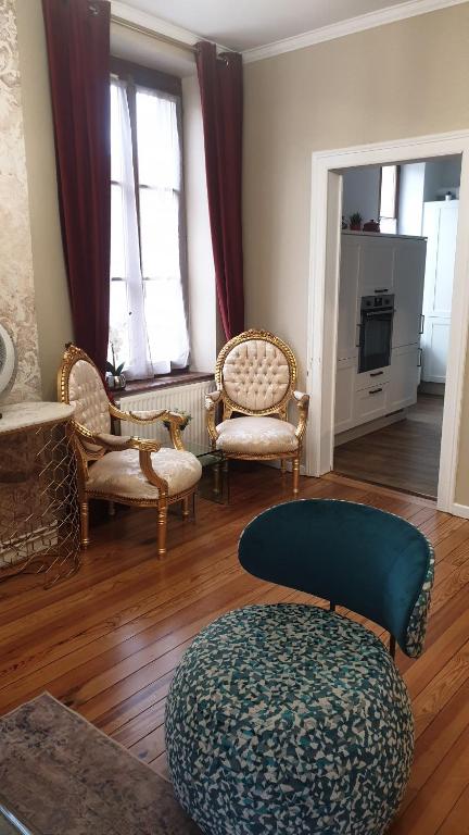a living room with chairs and a ottoman at Le LOUIS XV halte romantique à Metz centre in Metz