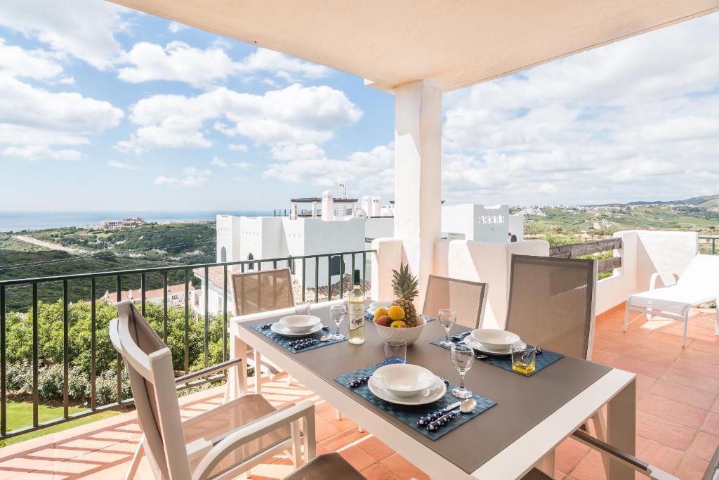 a dining table on a balcony with a view of the ocean at 2207-Modern apt with terrace and amazing seaview in Casares