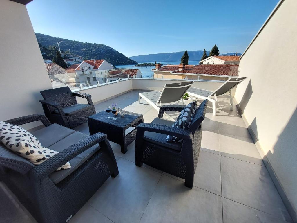 un patio con sillas y mesas en un balcón en Villa Luni, en Blace