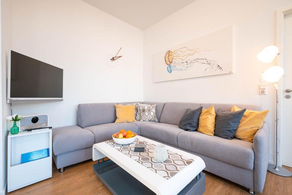 ein Wohnzimmer mit einem Sofa und einem Tisch in der Unterkunft Villa Anna -Whg 09 in Ahlbeck
