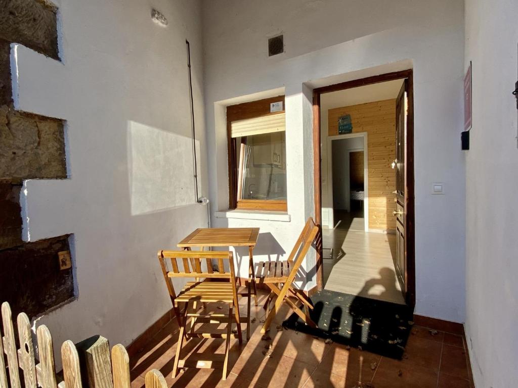 Zimmer mit 2 Stühlen, einem Tisch und einem Fenster in der Unterkunft la casita del puente viejo in Oruña