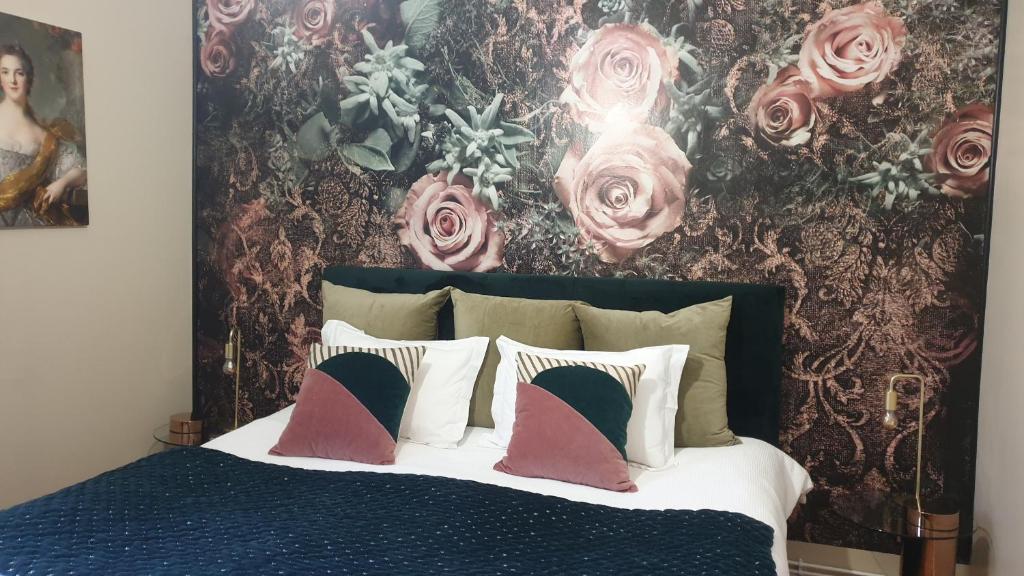 a bedroom with a bed with a floral wall at Le LOUIS XV halte romantique à Metz centre in Metz
