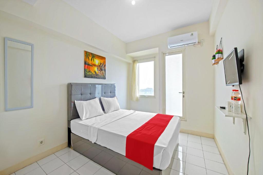 een slaapkamer met een bed en een tv. bij Skyland Podomoro Golf View Apartemen in Bogor