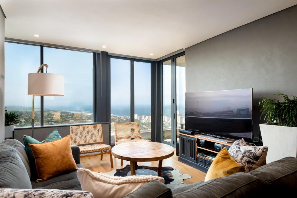 een woonkamer met een tafel en een groot scherm bij Umhlanga Arch, Luxury Sea View Apartment in Durban