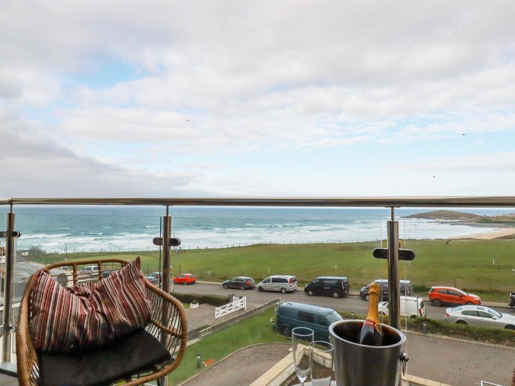 a balcony with a chair and a view of the ocean at Fistral Retreat in Newquay