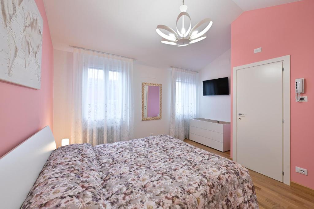 - une chambre avec un lit et un mur rose dans l'établissement Ca' 84 Burano, à Burano