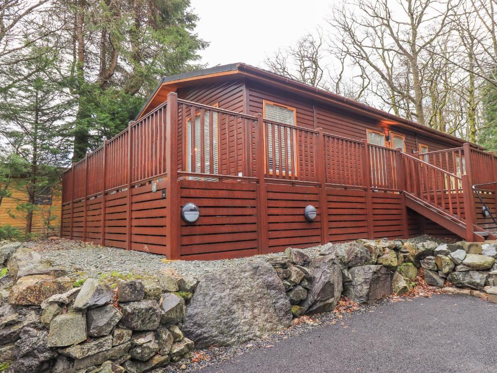 une grande cabane en bois sur un mur en pierre dans l'établissement 25 Thirlmere, à Windermere