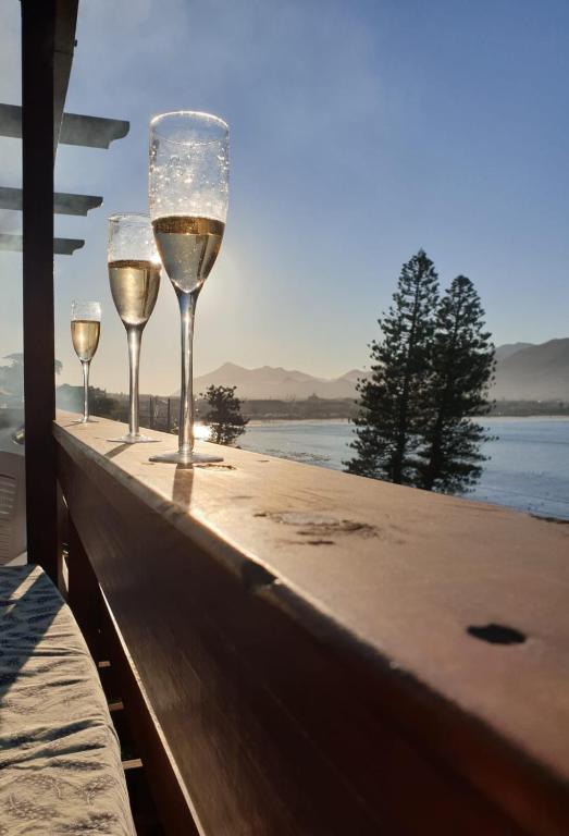 two glasses of white wine sitting on a wooden table at On the Sea in Cape Town