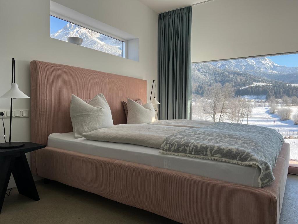 a bedroom with a large bed with a large window at Kaps Wohnen in Saalfelden am Steinernen Meer