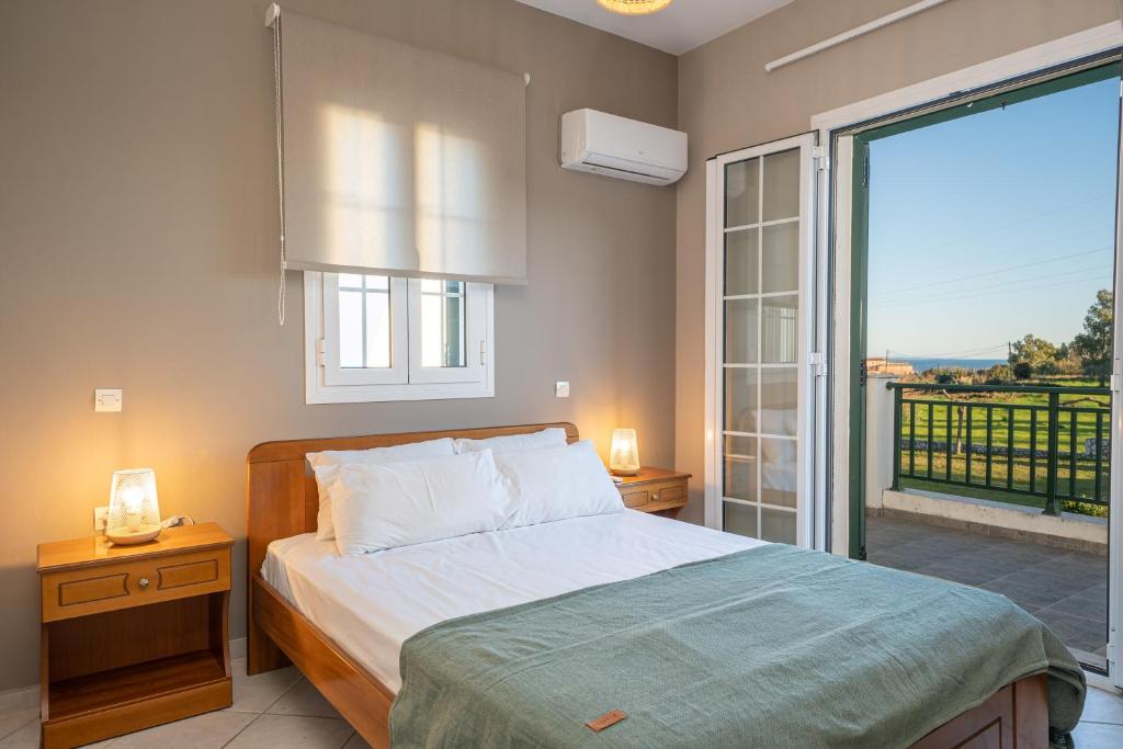 a bedroom with a bed and a large window at Captain's Villas in Katelios