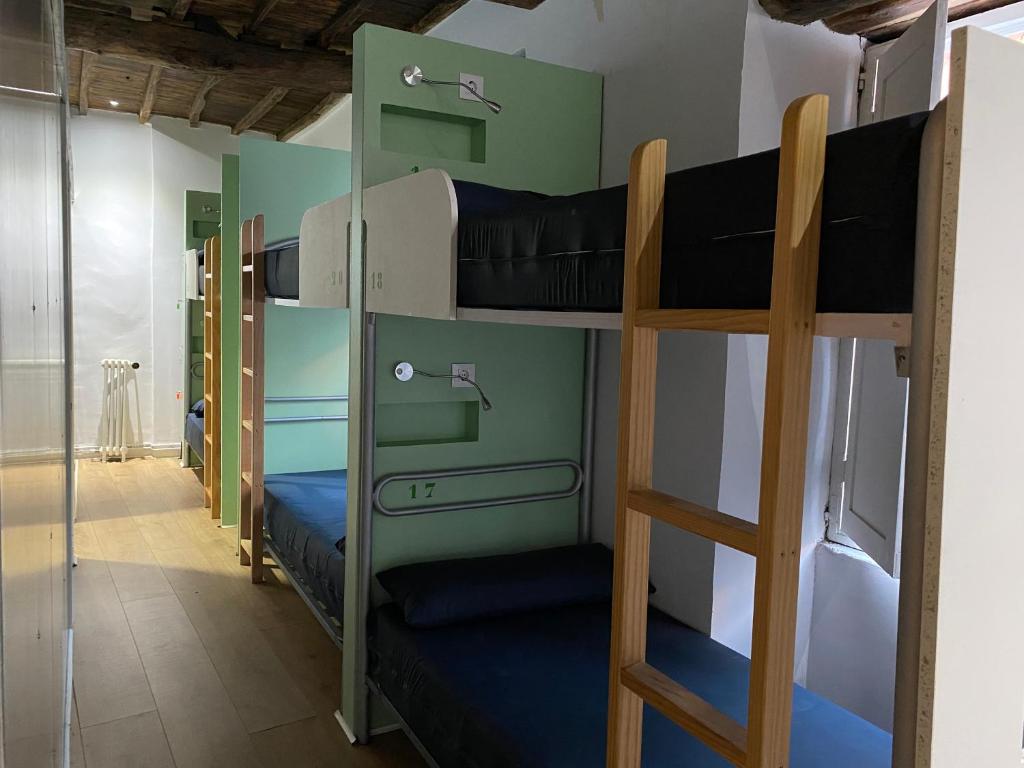 a room with three bunk beds in a room at Albergue O Santo in Arzúa