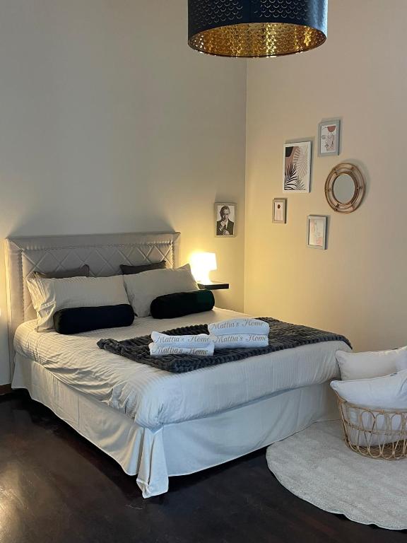 - une chambre avec un grand lit blanc et un lustre dans l'établissement MATTIA'S HOME, à Caserte