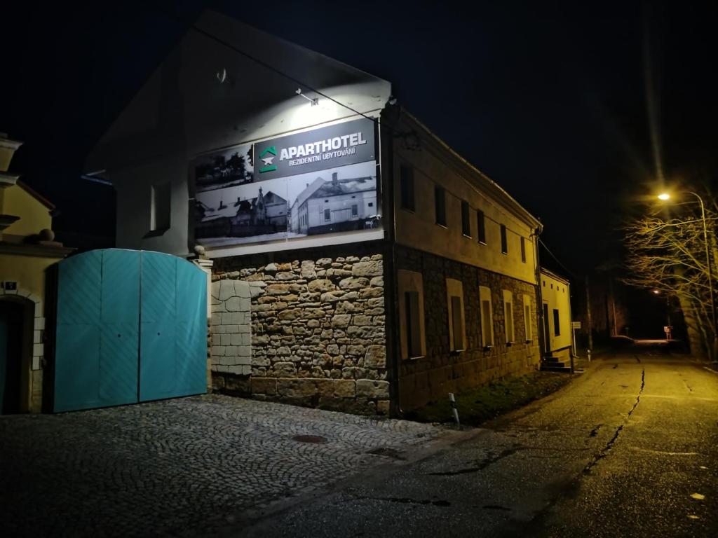un edificio con un cartel en su costado por la noche en Aparthotel Brokeš en Lanškroun