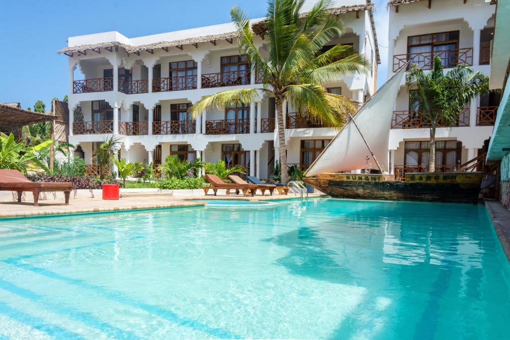 a swimming pool in front of a building at Nungwi Garden Boutique Hotel in Nungwi