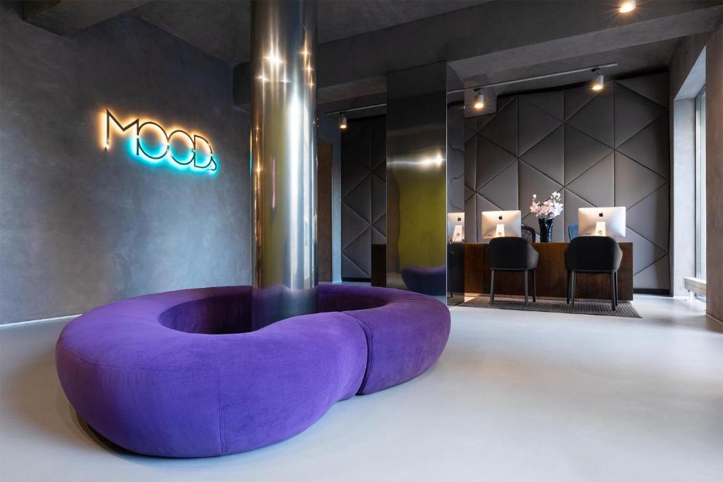 fioletowa kanapa siedząca w środku pokoju w obiekcie MOODs boutique hotel w Pradze