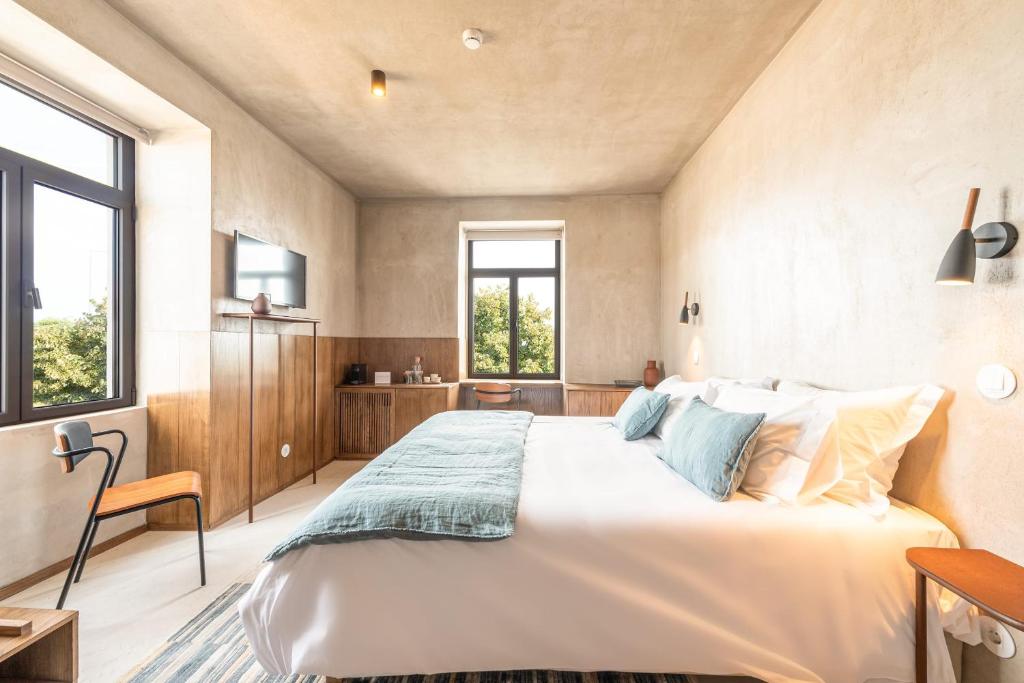een slaapkamer met een groot wit bed en ramen bij Azul by the Sea in Setúbal