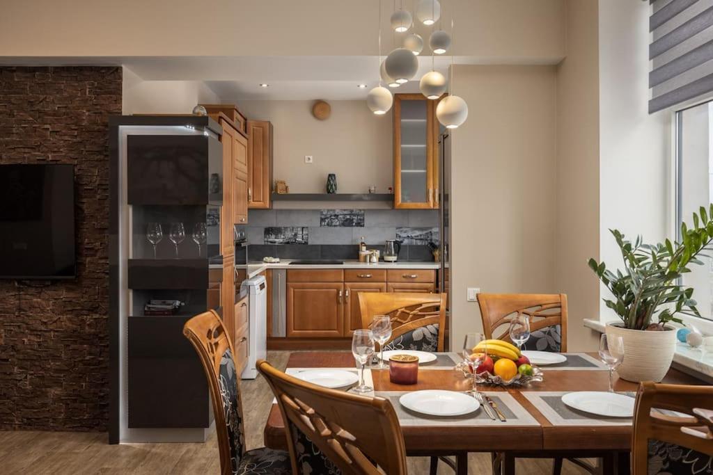 a kitchen with a wooden table and a dining room at Lovely 2-bdrm condo ideal for couples and family with children, free parking on premises in Riga