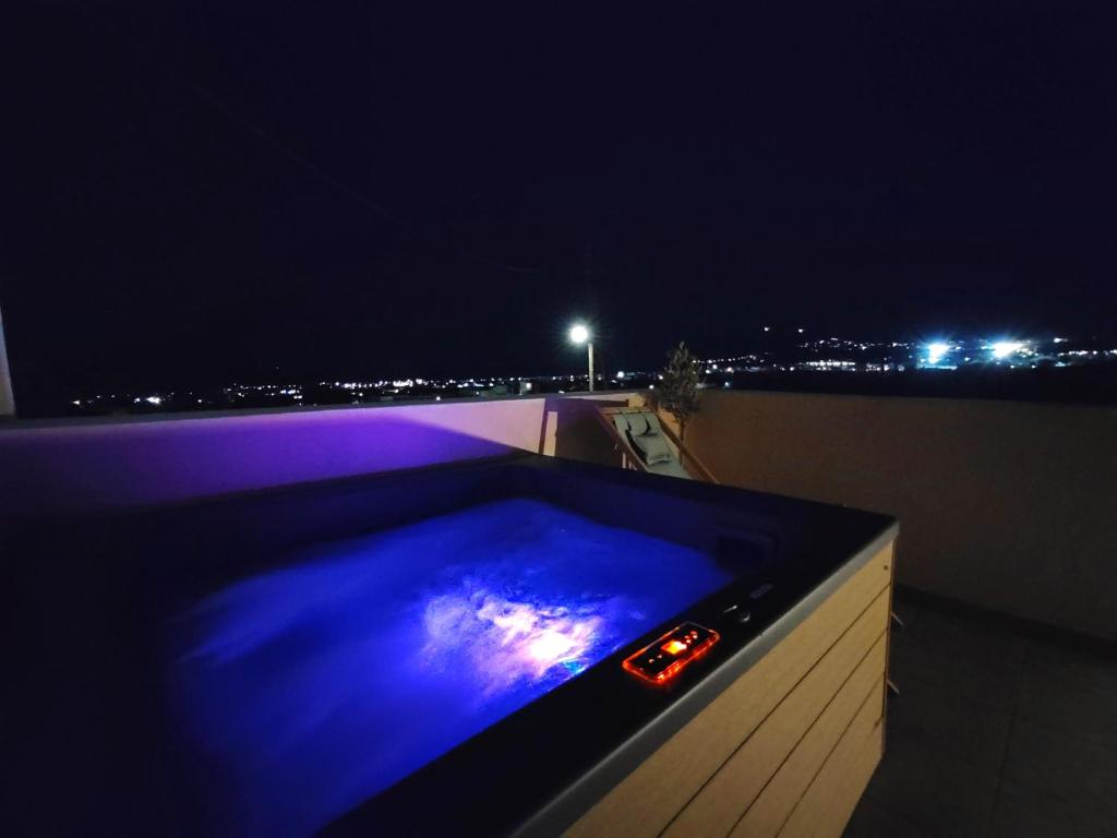 a hot tub on a rooftop at night at San Constantino Boutique Villa in Fira