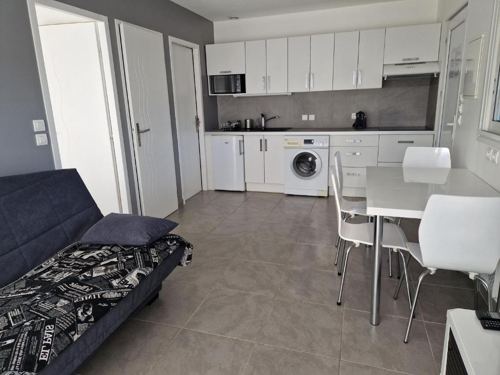 uma sala de estar com um sofá, uma mesa e uma cozinha em Beness'Appart 5km Capbreton em Bénesse-Maremne