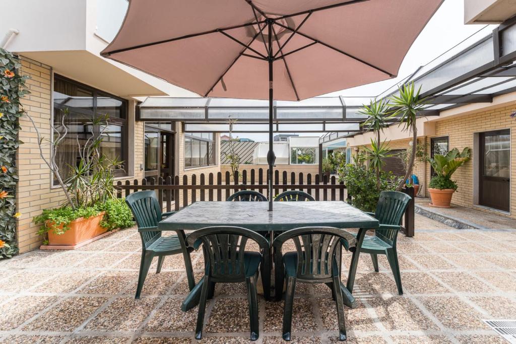 a patio with a table and chairs and an umbrella at Sea breeze retreat in Lavra in Lavra