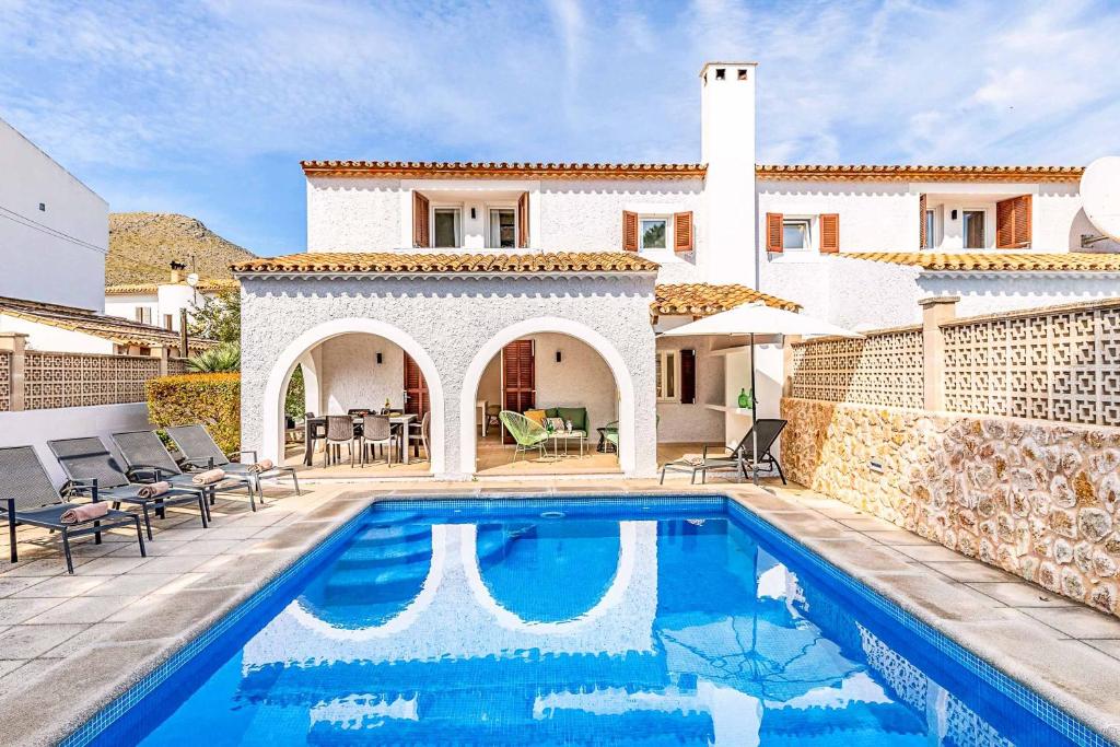 a villa with a swimming pool in front of a house at Villa Monsy 1 in El Port