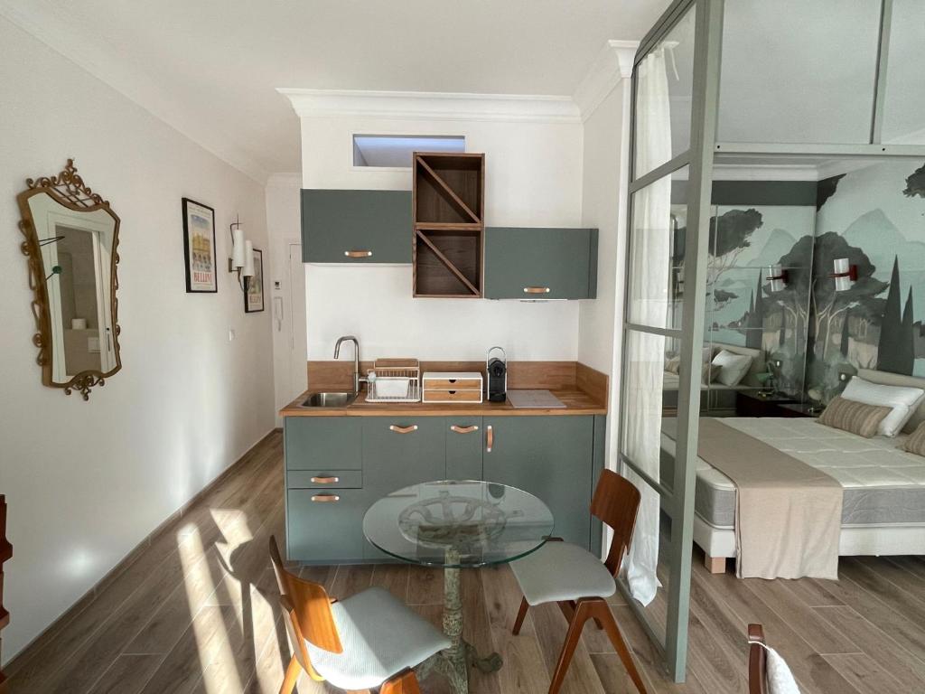 a small kitchen with a glass table and a bed at FELIX FAURE PALAIS DES FESTIVALS CROISETTE VIEUX PORT in Cannes