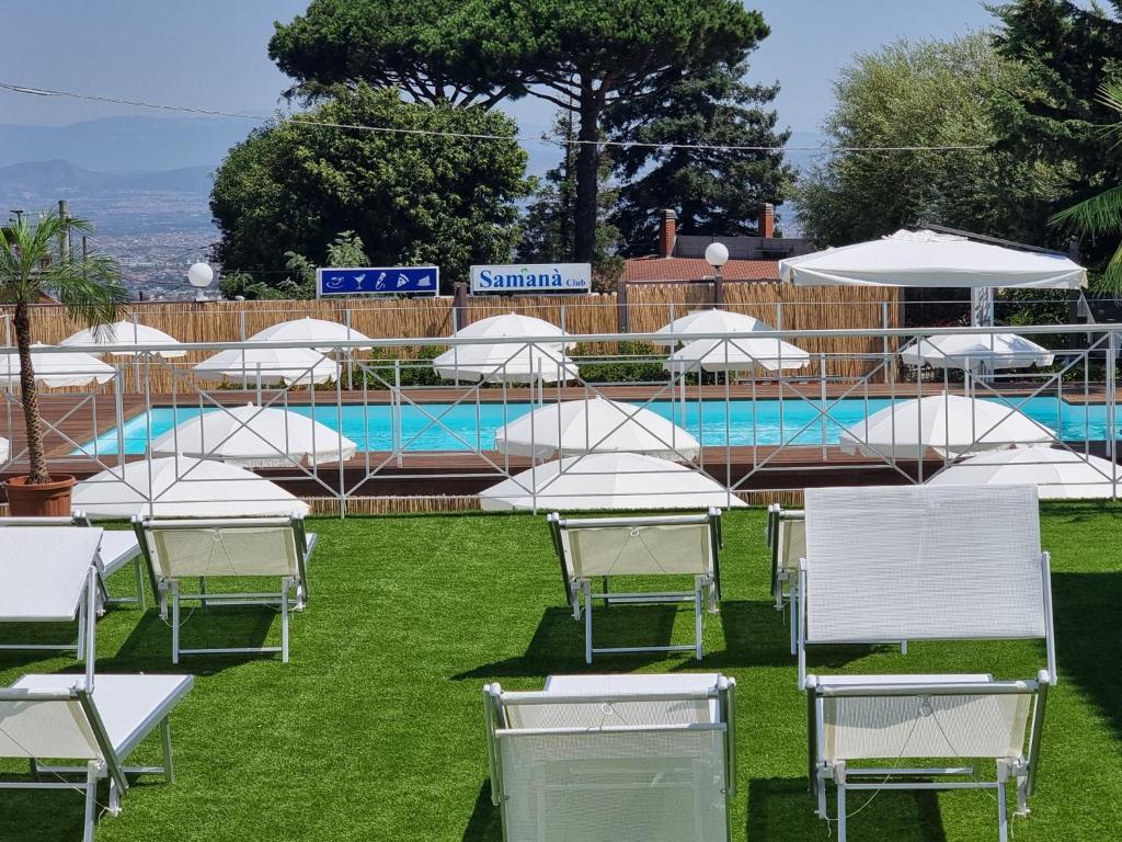 un gruppo di sedie e ombrelloni accanto alla piscina di Ranch Palace Hotel a Napoli