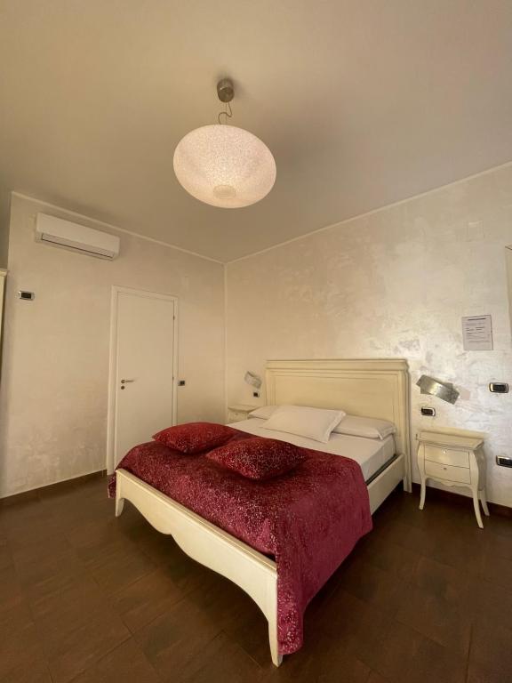 une chambre avec un grand lit avec une couverture rouge dans l'établissement B&B SALERNO IN, à Salerne